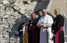  ?? Andrew Medichini/Associated Press ?? Pope Francis, surrounded by shells of destroyed churches, attends a prayer for the victims of war with Mosul and Aqra Archbishop Najib Mikhael Moussa, left, at Hosh al-Bieaa Church Square, in Mosul, Iraq, on Sunday.