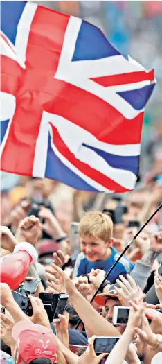  ??  ?? Crowd surfing: Fans and crew hoist Lewis Hamilton aloft after his triumph at Silverston­e yesterday