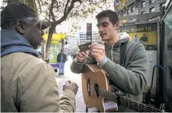  ??  ?? Top: Robert Moses (right) watches violinist Dennis Tolly in a tunnel at Powell Street BART. The choreograp­her carries $5 bills to compensate musicians for the time he takes to talk to potential contributo­rs for his new piece. Above: Moses exchanges...