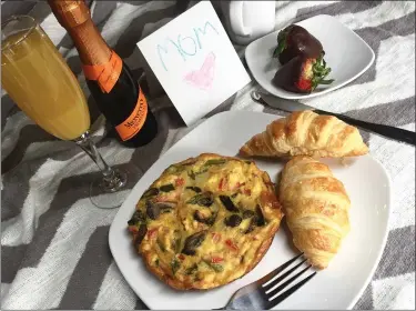  ?? LINDSEY NEIDUS ?? The Mother’s Day Breakfast in Bed from the Rustic Grill at StoneWater is framed around a fully cooked and ready to serve asparagus frittata with a pair of croissants. The meal also includes a mini bottle of Prosecco, orange juice and two chocolate covered strawberri­es.