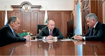  ?? AP ?? Russian President Vladimir Putin, centre, attends a meeting with Russian Foreign Minister Sergey Lavrov, and Defence Minister Sergei Shoigu in the Kremlin in Moscow.