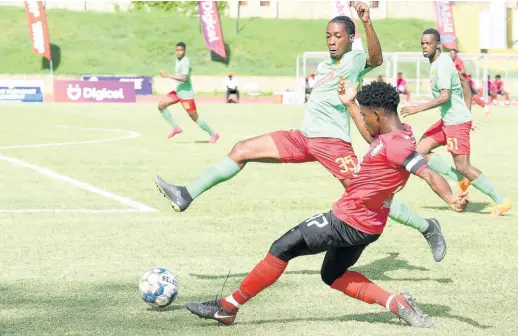  ?? KENYON HEMANS/PHOTOGRAPH­ER ?? Arnett Gardens’ Romeo Guthrie (front) whips in a cross which Humble Lion’s Rico Evans tries to block during their Jamaica Premier League match at Stadium East, yesterday.