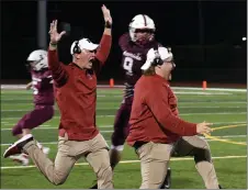  ?? PHOTOS BY DREW ELLIS — THE OAKLAND PRESS ?? Milford assistant coaches storm the field to celebrate the team’s 18-15 win over Walled Lake Western on Friday.