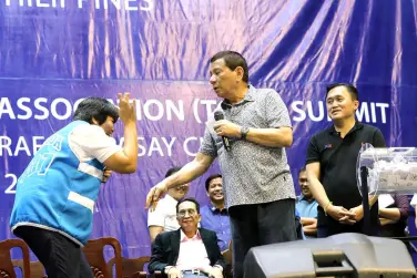  ??  ?? PRESIDENT Rodrigo R. Duterte enjoys a light moment with one of the raffle draw winners during the Tricycle Operators and Drivers’ Associatio­n (TODA) Summit at the Cuneta Astrodome in Pasay City. Presidenti­al Photo