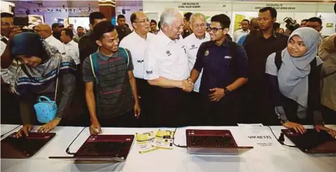  ??  ?? NAJIB beramah mesra dengan pelajar ketika melawat pameran selepas majlis perasmian Program MyApprenti­ceship di PWTC, Kuala Lumpur.