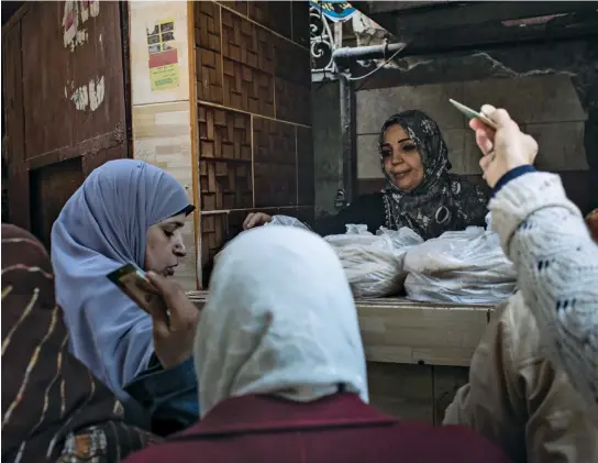  ??  ?? SOUR DOUGH: Customers buy subsidized bread in Cairo. Rising food prices have angered many across the country.