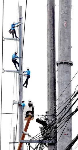  ?? ANALY LABOR ?? Balancing Act These linemen from Meralco resemble high-wire artists as they repair power lines in Barangay Batasan, Quezon City.