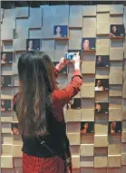  ?? WANG HAIBIN / FOR CHINA DAILY ?? A visitor takes photos of a picture wall for renowned actors and actresses in the Qingdao Film Museum.