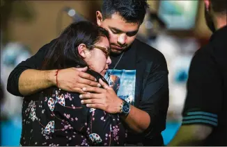  ?? AMANDA VOISARD / AMERICAN-STATESMAN ?? Miguel Hernandez, 17, and Thelma Manzano, 19, embrace after a vigil in honor of longtime friend Draylen Mason, the 17-year-old victim killed in the second Austin package bombing. The vigil was held at the East Austin College Prep on Tuesday evening.