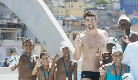  ??  ?? UN GRUPO de niños pobres de Brasil comparte con el nadador Michael Phelps en la actividad organizada por la Fundación Laureus.