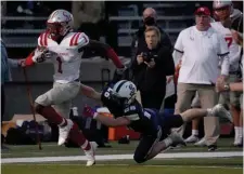  ?? MARy scHwALm pHOTOs / bOsTOn HeRALd ?? JUST OUT OF REACH: Catholic Memorial running back Datrell Jones runs down the sideline ahead of a diving tackle attempt by St. John’s Prep defensive back Austin Lambert during the first half Friday night in Danvers.