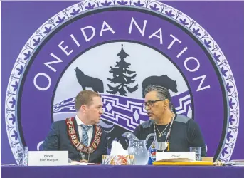  ?? DEREK RUTTAN ?? Oneida Nation of the Thames Chief Todd Cornelius, right, speaks with London Mayor Josh Morgan during a special joint council meeting at the Oneida Community Centre in Southwold Township Wednesday.