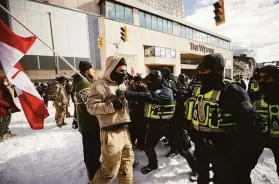  ?? Cole Burston / Canadian Press ?? Police confront protesters in Ottawa as officers began dismantlin­g a demonstrat­ion against coronaviru­s restrictio­ns that has gridlocked the city.