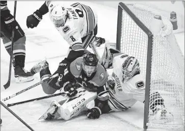  ?? John Cordes Associated Press ?? DUCKS CENTER Adam Henrique skates into Vancouver Canucks goalie Jacob Markstrom at the Honda Center, where Anaheim won for the first time in two months behind a goalie making his first NHL start.