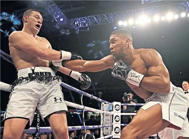  ??  ?? Defences breached: Anthony Joshua finds a way through against Joseph Parker in a fight that was frequently halted by the Italian referee (below)