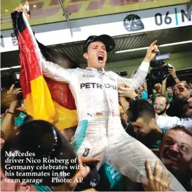  ??  ?? Mercedes driver Nico Rosberg of Germany celebrates with his teammates in the team garage Photo: AP