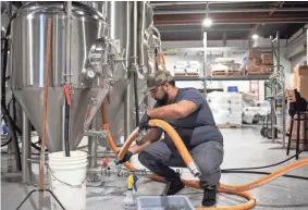  ?? SEAN LOGAN/USA TODAY NETWORK ?? Tyler Smith sanitizes a fermenter at Simple Machine Brewing Company in Phoenix. He rents space for Kitsune Brewing Co.