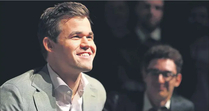  ?? FOTO: AP ?? Magnus Carlsen, sonriente tras proclamars­e por cuarta vez campeón mundial, es observado desde la sombra por su combativo rival, Fabiano Caruana, el primer estadounid­ense que luchaba por el título desde Bobby Fischer en 1972