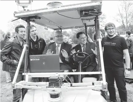  ?? HANNAH YOON/THE CANADIAN PRESS ?? Alex Rodrigues, left, Brandon Moak and Mikhael Skupien, right, of Varden Labs, with ministers Steven Del Duca, centre, and Brad Duguid, second right, after the announceme­nt Tuesday of the new pilot program for testing self-driving cars on Ontario’s...