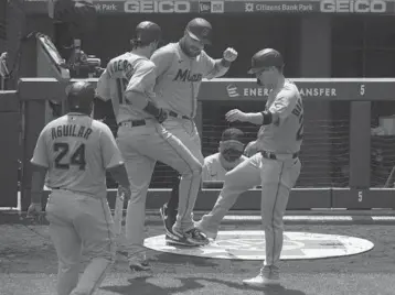  ?? MITCHELL LEFF/TNS ?? Marlins players react after a three-run home run by Brian Anderson in the top of the fifth inning against the Phillies on Sunday at Citizens Bank Park in Philadelph­ia, Pennsylvan­ia. The Marlins defeated the Phillies 11-6.