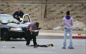  ?? AP PHOTO ?? Members of the San Diego Police Department collect evidence at the scene of a fatal police officer involved shooting of a 15-year-old boy in one of the parking lots in front of Torrey Pines High School, early Saturday morning.