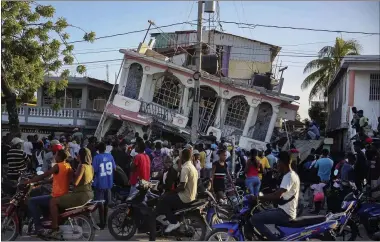  ?? JOSEPH ODELYN—ASSOCIATED PRESS ?? People gather outside the Petit Pas Hotel, destroyed by the earthquake in Les Cayes, Haiti, Saturday, Aug. 14, 2021. A 7.2magnitude earthquake struck Haiti on Saturday, with the epicenter about 125kilomet­ers (78miles) west of the capital of Port-au-prince, the US Geological Survey said.