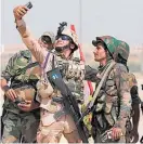  ?? Photo / AP ?? Iraqi and Syrian troops take selfies at the border crossing.