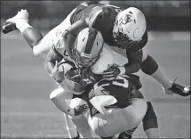  ?? JESSICA HILL/AP FILE PHOTO ?? URI quarterbac­k JaJuan Lawson (15) is sandwiched in a tackle by UConn linebacker Kevon Jones, top, and defensive back Tyler Coyle, bottom, in a game on Sept. 15 in East Hartford.