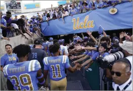  ?? ASHLEY LANDIS — THE ASSOCIATED PRESS FILE ?? UCLA football players greet fans as they leave the field after a 42-32win over Utah in Pasadena on Oct. 8. UCLA cleared a major hurdle toward joining the Big Ten Conference in 2024, getting approval for the move from the University of California Board of Regents on Wednesday.