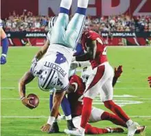  ?? AP ?? Dallas Cowboys quarterbac­k Dak Prescott (4) dives for a touchdown as Arizona Cardinals cornerback Justin Bethel (28) defends during the first half on Monday.