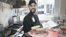  ?? DAN JANISSE ?? Roger Poirier displays a fresh sandwich at the The Downtown Mission’s Do Good Deli, which officially opened on Monday.