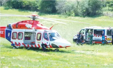  ??  ?? Air and road ambulance paramedics assist at the scene where a female motorcycli­st came off her motorcycle on Grand Ridge Rd at Seaview on Saturday afternoon.
