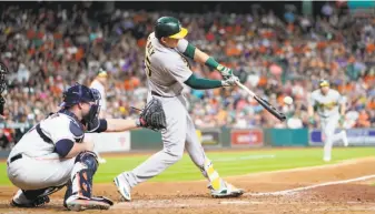  ?? David J. Phillip / Associated Press ?? Ryon Healy hits a grand slam in the sixth inning of the A’s 6-4 win over the Astros. It was the 10th homer in June and the 18th this season for Oakland’s infielder and DH.