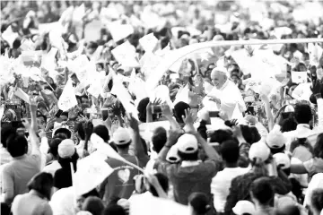  ??  ?? Pope Francis waves to the Catholic faithful as he arrives at the stadium where he is scheduled to say mass in Yangon. — AFP photo