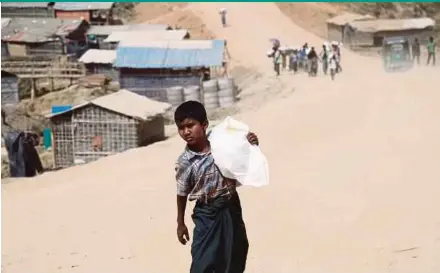  ?? EPA PIC ?? A boy carrying relief goods at the site of the newly extended refugee camps at Kutupalong in Ukhiya, Cox’s Bazar, Bangladesh, on Monday.