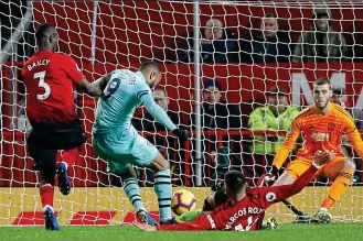  ?? REUTERS/ACTION IMAGES ?? Sliding tackle: United’s Marcos Rojo tries to recover after a misplaced pass but his last-gasp challenge on Arsenal’s Alexandre Lacazette is too late and the ball ricochets off the Frenchman’s shin into the net