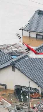  ??  ?? A resident is rescued in a flooded area in Kurashiki, Okayama prefecture, following heavy rain.