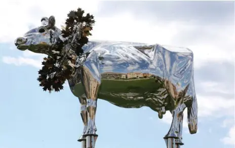 ?? STEVE RUSSELL/TORONTO STAR ?? Residents want this towering sculpture of Charity, a prizewinni­ng cow, moved from their parkette to a nearby pond, where it would be less obtrusive.