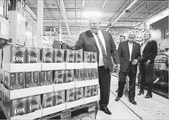  ?? COLE BURSTON
THE CANADIAN PRESS ?? Ontario Premier Doug Ford slaps the top of boxes of beer as Ontario Finance Minister Vic Fedeli laughs in background at Cool Brewery in Toronto on Monday.