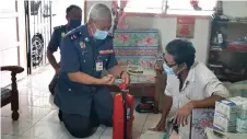  ??  ?? Law (centre) demonstrat­es the proper use of a fire extinguish­er to Chin during the visit.