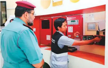  ??  ?? Civil Defence officials inspect the fire alarm installati­on system at a building.