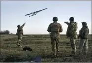  ?? AP PHOTO/LIBKOS, FILE ?? FILE - Ukrainian soldiers launch a drone at Russian positions near Bakhmut, Donetsk region, Ukraine, Thursday, Dec. 15, 2022.
