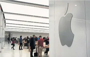  ?? SPENCER PLATT GETTY IMAGES ?? Customers wait for service in an Apple store in New York City. The tech giant is facing reports of suppliers cutting forecasts, signalling new iPhone models aren’t selling as well as anticipate­d.