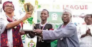  ??  ?? FCT Sports Director, Chief Dilichukwu Onyedinma presenting the trophy to Flomat FC captain alongside FCT FA Chairman, Alh Musa Talle