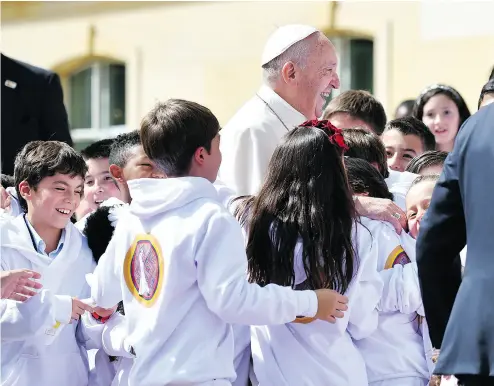  ?? ALBERTO PIZZOLI / AFP / GETTY IMAGES ?? Pope Francis is greeted and hugged by children at the presidenti­al palace in Bogota on Thursday.