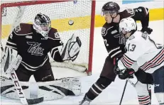  ?? CLIFFORD SKARSTEDT EXAMINER ?? Peterborou­gh Petes goalie Hunter Jones makes a glove save as teammate Cole Fraser ties up Oshawa Generals’ Brett Neumann during OHL action on Thursday night at the Memorial Centre.