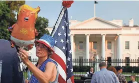  ?? AP ?? A protester holds a Baby Trump balloon outside the White House.