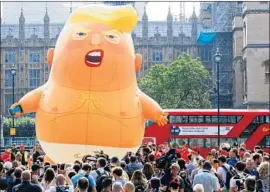  ?? Luke MacGregor Bloomberg ?? DEMONSTRAT­ORS cheered as a blimp mocking President Trump was sent aloft from Parliament Square in London. “Trump go home,” one placard read.