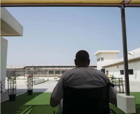  ?? Antonie Robertson / The National ?? The inmate, who is in a wheelchair after a hernia operation, reads the Quran at Dubai Central Jail