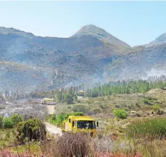WALKER Bay fire­fight­ers con­duct mop-up op­er­a­tions in the Grabouw For­est. |